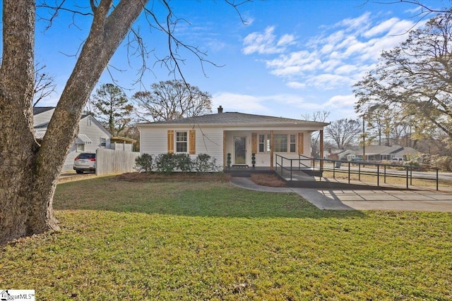 view of front facade featuring a front lawn, a porch, and fence