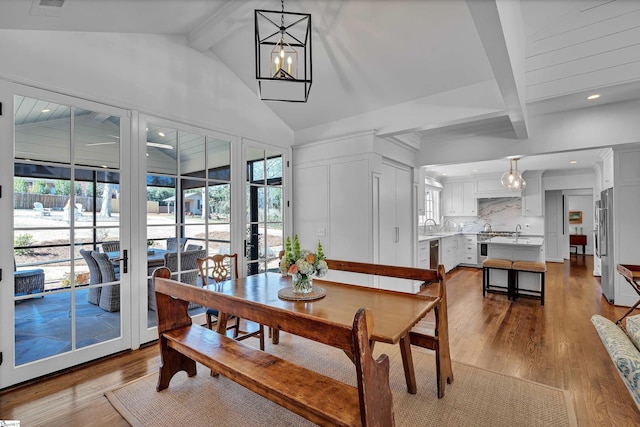 dining space with lofted ceiling with beams, dark wood-type flooring, a chandelier, and recessed lighting