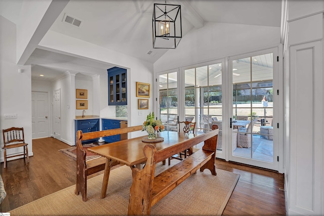 dining area with a chandelier, beam ceiling, visible vents, and dark wood finished floors