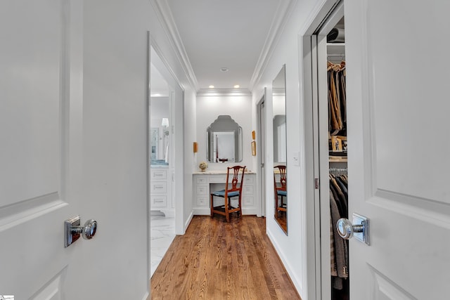 hallway featuring light wood-style flooring, crown molding, and recessed lighting