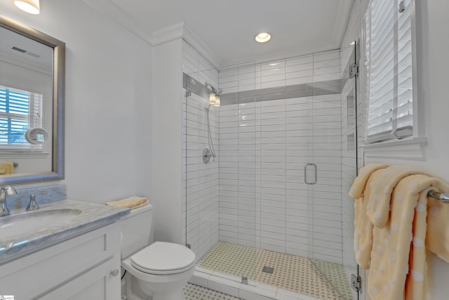 bathroom with crown molding, visible vents, toilet, a shower stall, and vanity