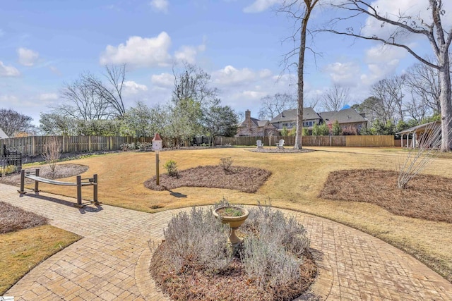 view of home's community with a lawn, a patio area, and fence private yard