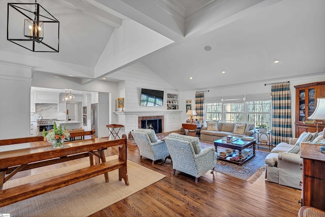 living area with vaulted ceiling with beams, a chandelier, recessed lighting, a fireplace, and wood finished floors