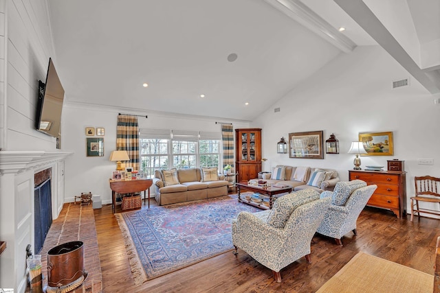 living room with visible vents, wood finished floors, beamed ceiling, a fireplace, and high vaulted ceiling