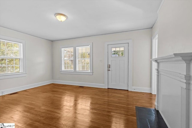 foyer entrance with visible vents, baseboards, and wood finished floors