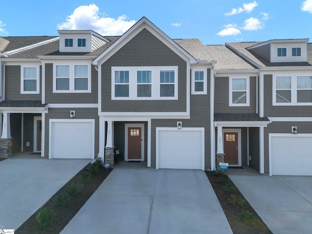 view of property featuring a shingled roof, driveway, and an attached garage