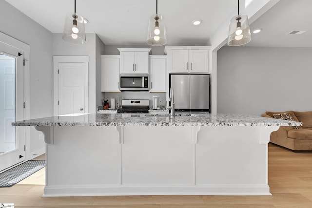 kitchen featuring stainless steel appliances, a sink, and a kitchen breakfast bar