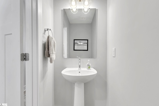 bathroom with a notable chandelier