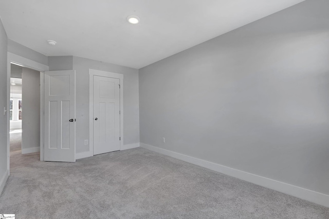 unfurnished bedroom with light colored carpet and baseboards