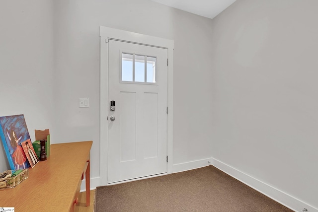 foyer entrance featuring dark colored carpet and baseboards