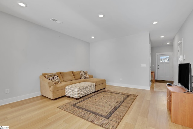 living area featuring light wood finished floors, baseboards, and recessed lighting