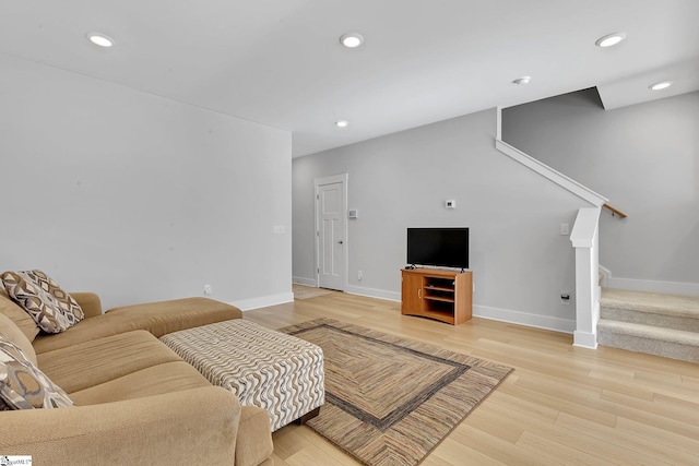 living area featuring light wood-type flooring, baseboards, recessed lighting, and stairs