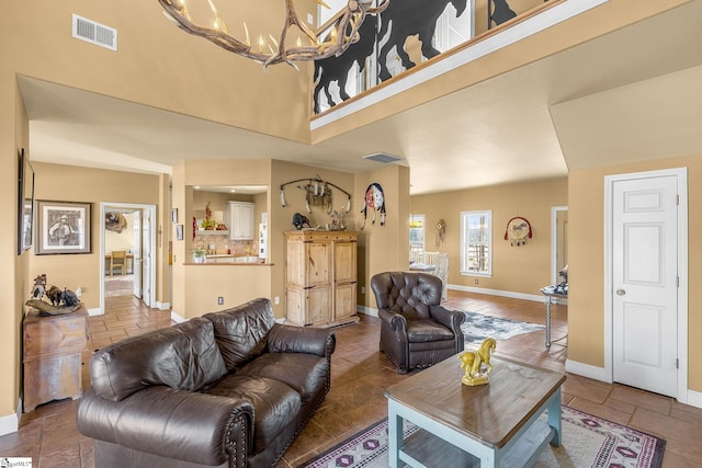 4101 Abbeville Hwy, Anderson, SC 29624 - living room featuring baseboards, a high ceiling, visible vents, and stone tile floors