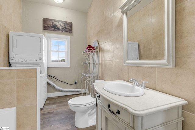 4101 Abbeville Hwy, Anderson, SC 29624 - full bathroom featuring tile walls, toilet, stacked washer / dryer, vanity, and wood finished floors