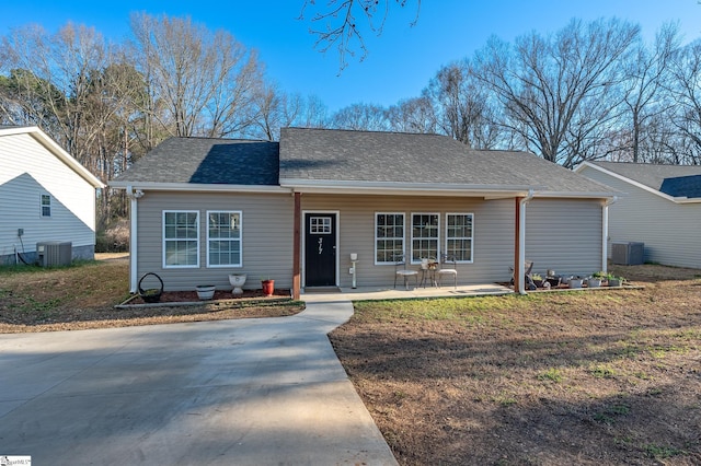 view of front of house with central AC unit and roof with shingles