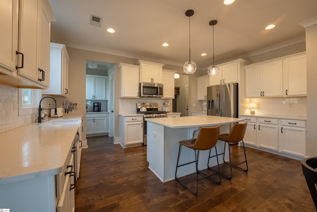 kitchen featuring stainless steel appliances, visible vents, dark wood-type flooring, and white cabinetry