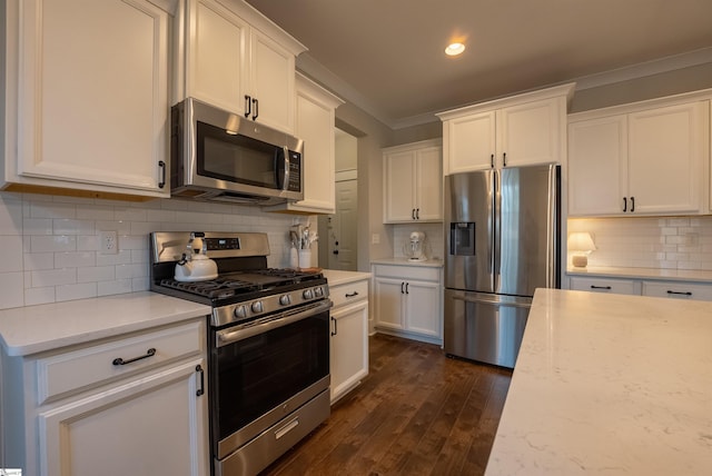 kitchen with white cabinetry, appliances with stainless steel finishes, and crown molding