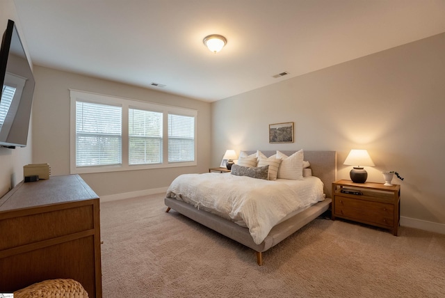 bedroom featuring light colored carpet, visible vents, and baseboards