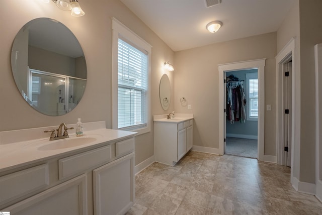 full bathroom with a healthy amount of sunlight, two vanities, and a sink