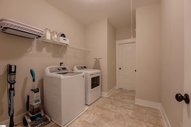 washroom with laundry area, washer and clothes dryer, and baseboards