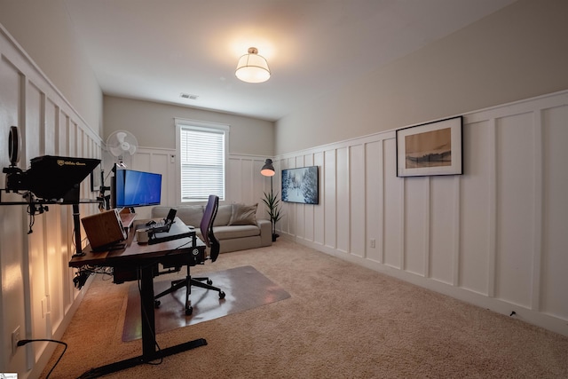 carpeted office featuring wainscoting, visible vents, and a decorative wall