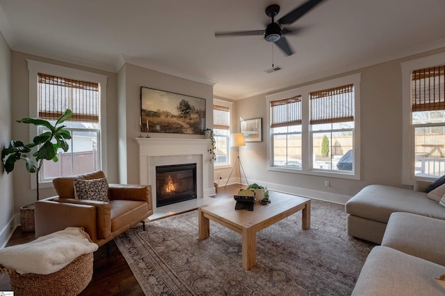 living room featuring dark wood-style floors, a healthy amount of sunlight, crown molding, and baseboards