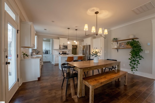 dining area with baseboards, visible vents, dark wood-style floors, ornamental molding, and a chandelier