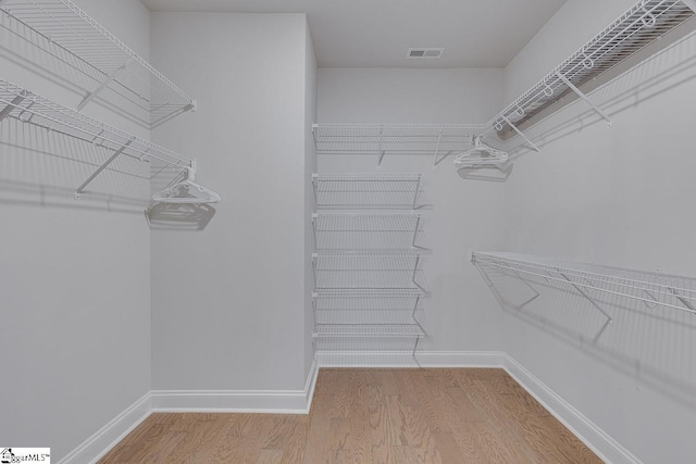 spacious closet featuring wood finished floors and visible vents