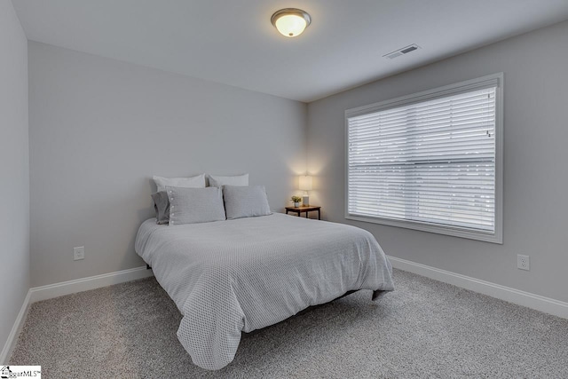 carpeted bedroom featuring baseboards and visible vents