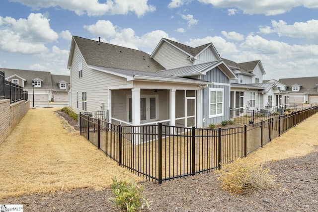 view of front of house with a fenced backyard, metal roof, a standing seam roof, french doors, and board and batten siding