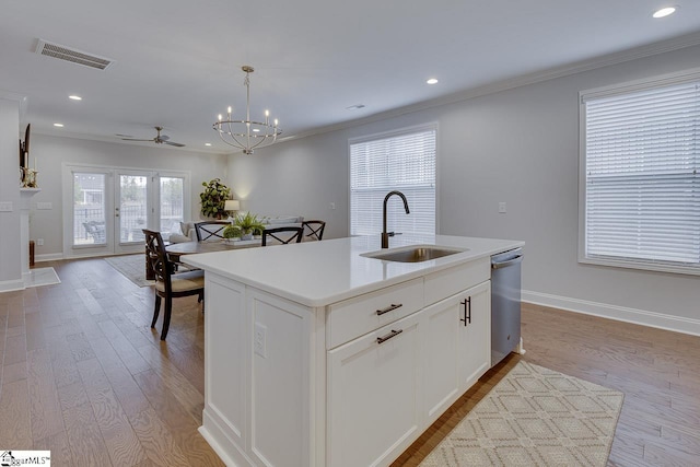 kitchen featuring visible vents, dishwasher, ornamental molding, wood finished floors, and a sink