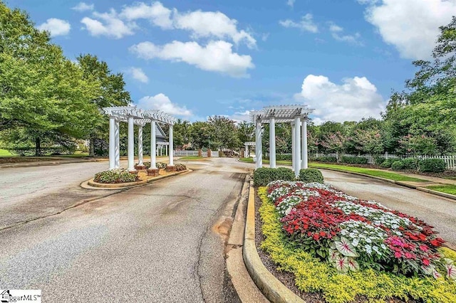 view of street with curbs and a gated entry