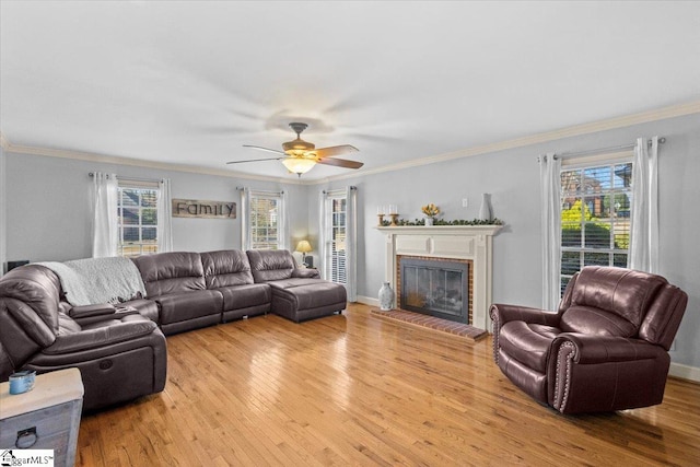 living room with a brick fireplace, light wood-style flooring, and ornamental molding