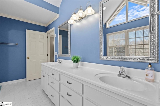 full bath with double vanity, crown molding, baseboards, and a sink