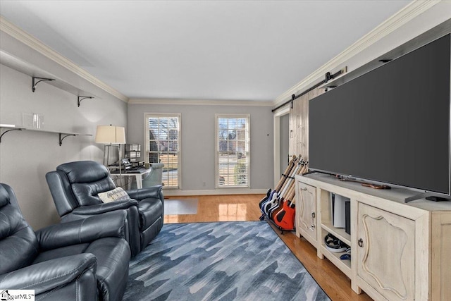 living room with baseboards, a barn door, wood finished floors, and crown molding