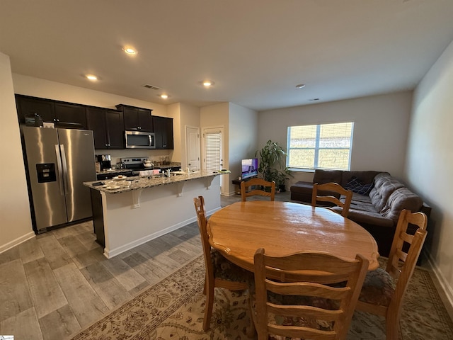 dining area featuring light wood-style flooring, visible vents, baseboards, and recessed lighting