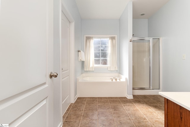 bathroom featuring tile patterned floors, a shower stall, a bath, and vanity