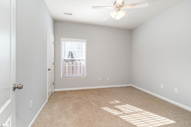 spare room with ceiling fan, carpet floors, visible vents, and baseboards