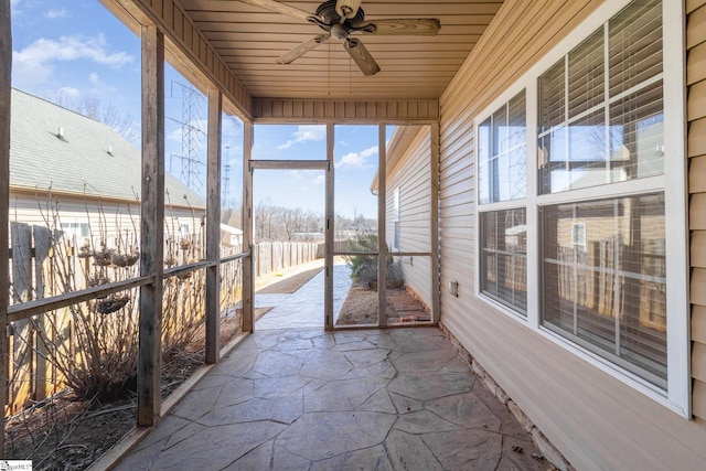 unfurnished sunroom featuring wood ceiling and ceiling fan