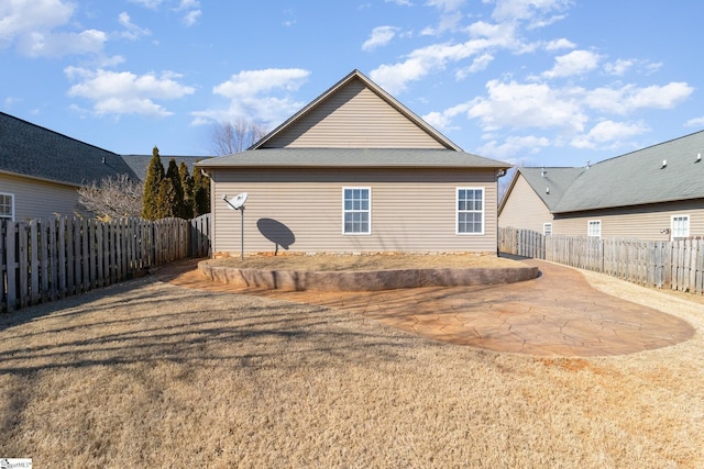 rear view of property featuring a patio area, a fenced backyard, and a yard