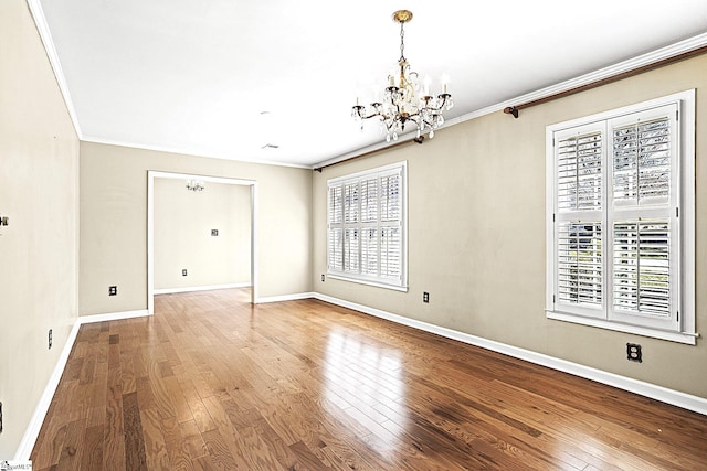 unfurnished room featuring baseboards, ornamental molding, a chandelier, and hardwood / wood-style floors