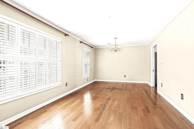 unfurnished dining area featuring baseboards, hardwood / wood-style floors, an inviting chandelier, and crown molding