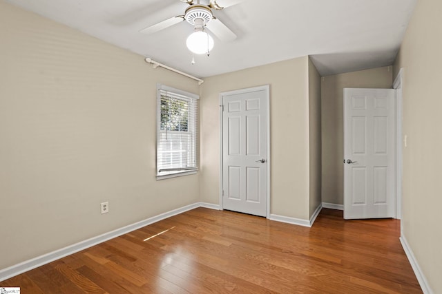 unfurnished bedroom featuring wood finished floors, a ceiling fan, and baseboards