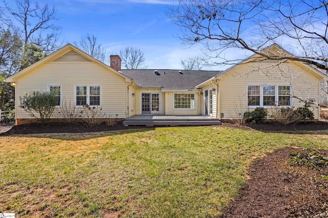 back of property featuring a yard, a chimney, and a wooden deck