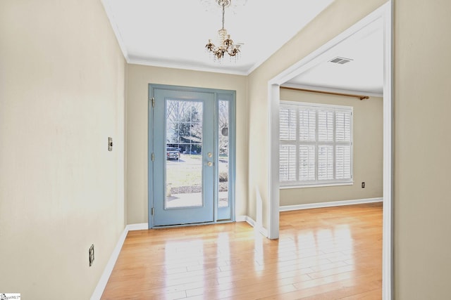 foyer with light wood-type flooring, a wealth of natural light, and visible vents