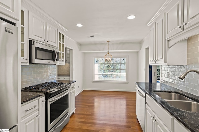 kitchen featuring visible vents, white cabinets, appliances with stainless steel finishes, crown molding, and a sink