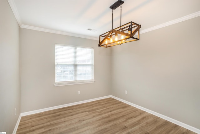 spare room featuring visible vents, crown molding, light wood-style flooring, and baseboards