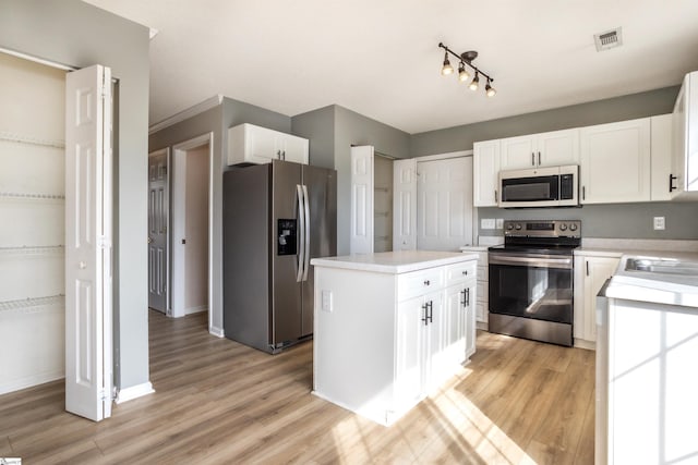 kitchen featuring visible vents, white cabinetry, light countertops, appliances with stainless steel finishes, and light wood finished floors