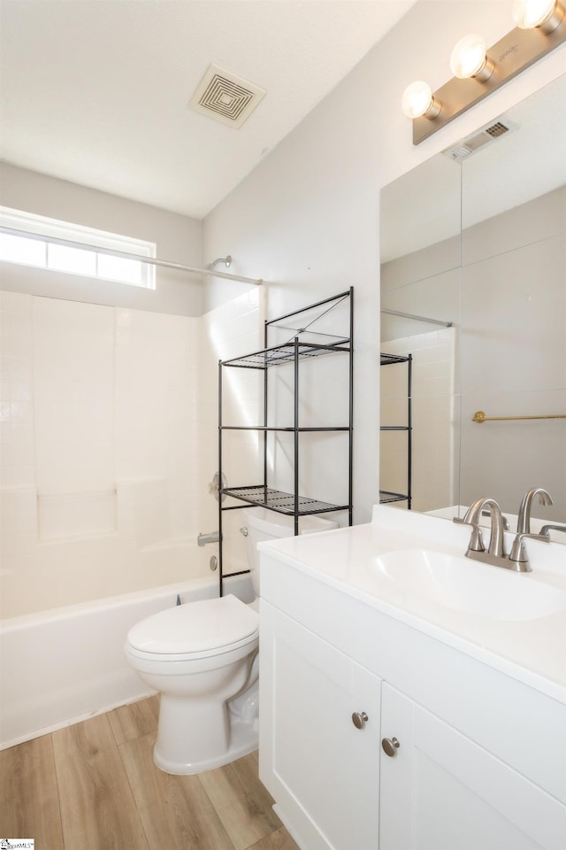 bathroom with shower / bathtub combination, toilet, wood finished floors, vanity, and visible vents