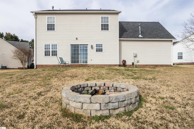 back of property featuring an outdoor fire pit, cooling unit, and a yard